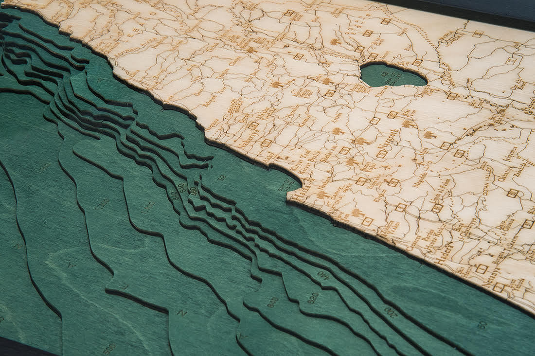 Israel 3D layered wood map in laser-cut Baltic birch, shown framed against a light wall