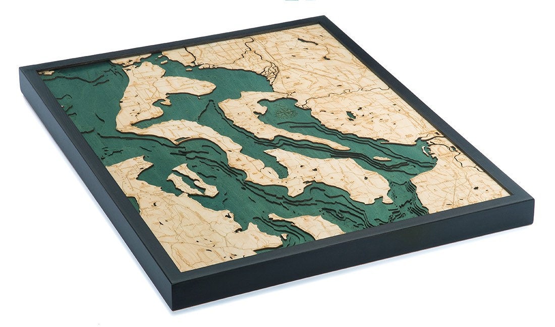 Whidbey & Camano Islands, Washington 3D layered wood map in laser-cut Baltic birch, shown framed against a light wall