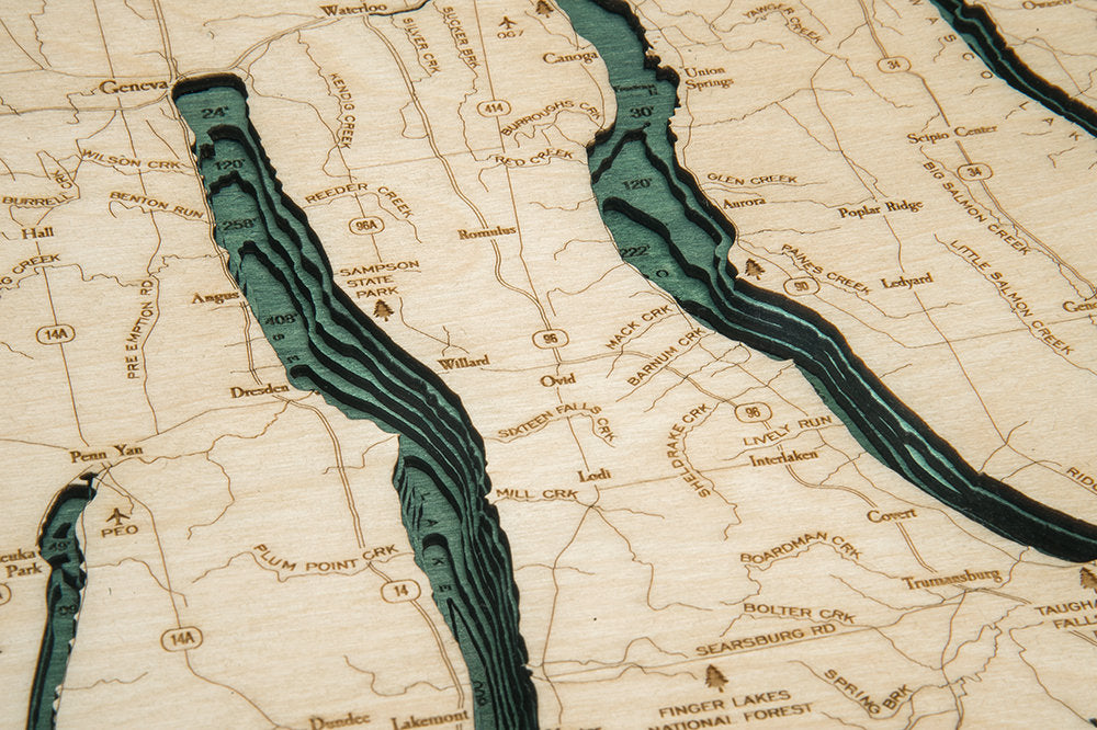 Finger Lakes, New York 3D layered wood map in laser-cut Baltic birch, shown framed against a light wall