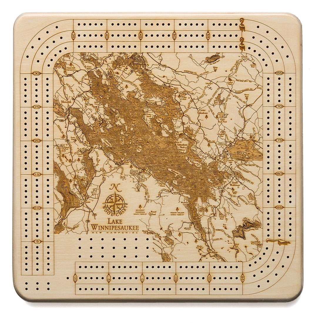 Lake Winnipesaukee, New Hampshire wood cribbage board in laser-cut Baltic birch, shown framed against a light wall