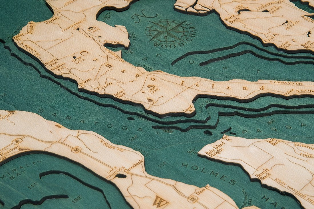 Whidbey & Camano Islands, Washington 3D layered wood map in laser-cut Baltic birch, shown framed against a light wall