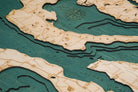 Whidbey & Camano Islands, Washington 3D layered wood map in laser-cut Baltic birch, shown framed against a light wall