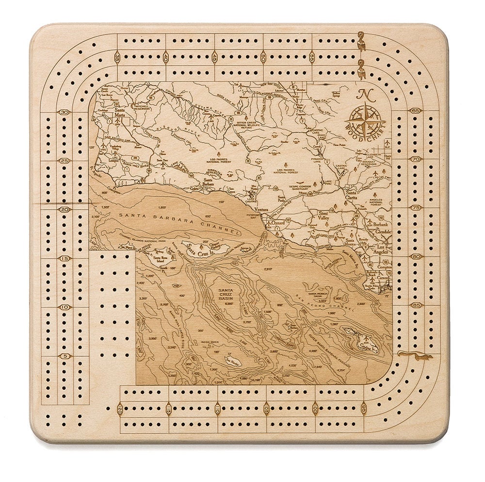 Santa Barbara, California wood cribbage board in laser-cut Baltic birch, shown framed against a light wall