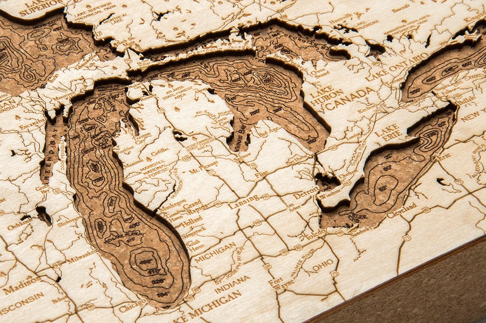 Great Lakes framed cork map in laser-cut Baltic birch, shown framed against a light wall
