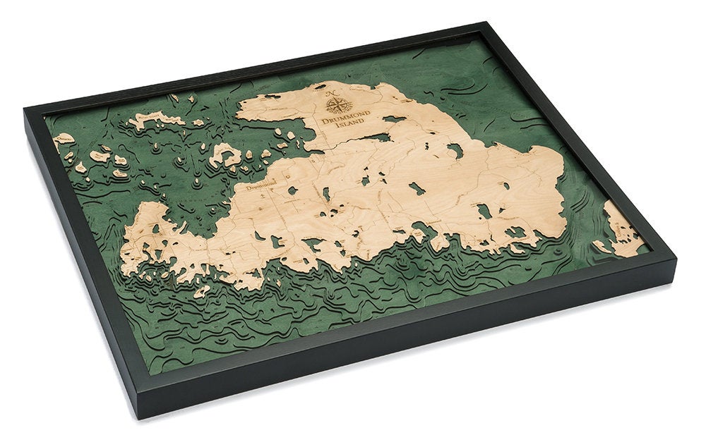 Drummond Island, Michigan 3D layered wood map in laser-cut Baltic birch, shown framed against a light wall