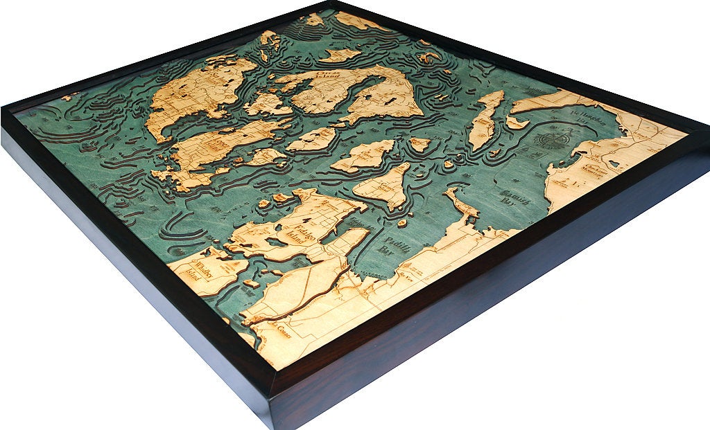San Juan Islands, Washington 3D layered wood map in laser-cut Baltic birch, shown framed against a light wall