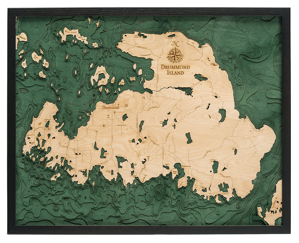 Drummond Island, Michigan 3D layered wood map in laser-cut Baltic birch, shown framed against a light wall