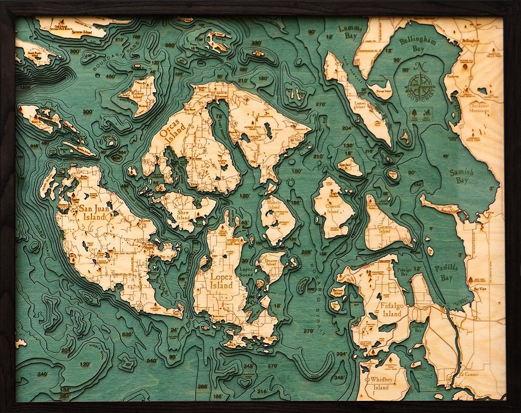 San Juan Islands, Washington 3D layered wood map in laser-cut Baltic birch, shown framed against a light wall