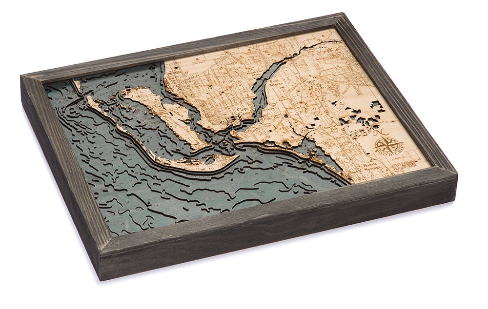 Fort Myers, Florida 3D layered wood map in laser-cut Baltic birch, shown framed against a light wall