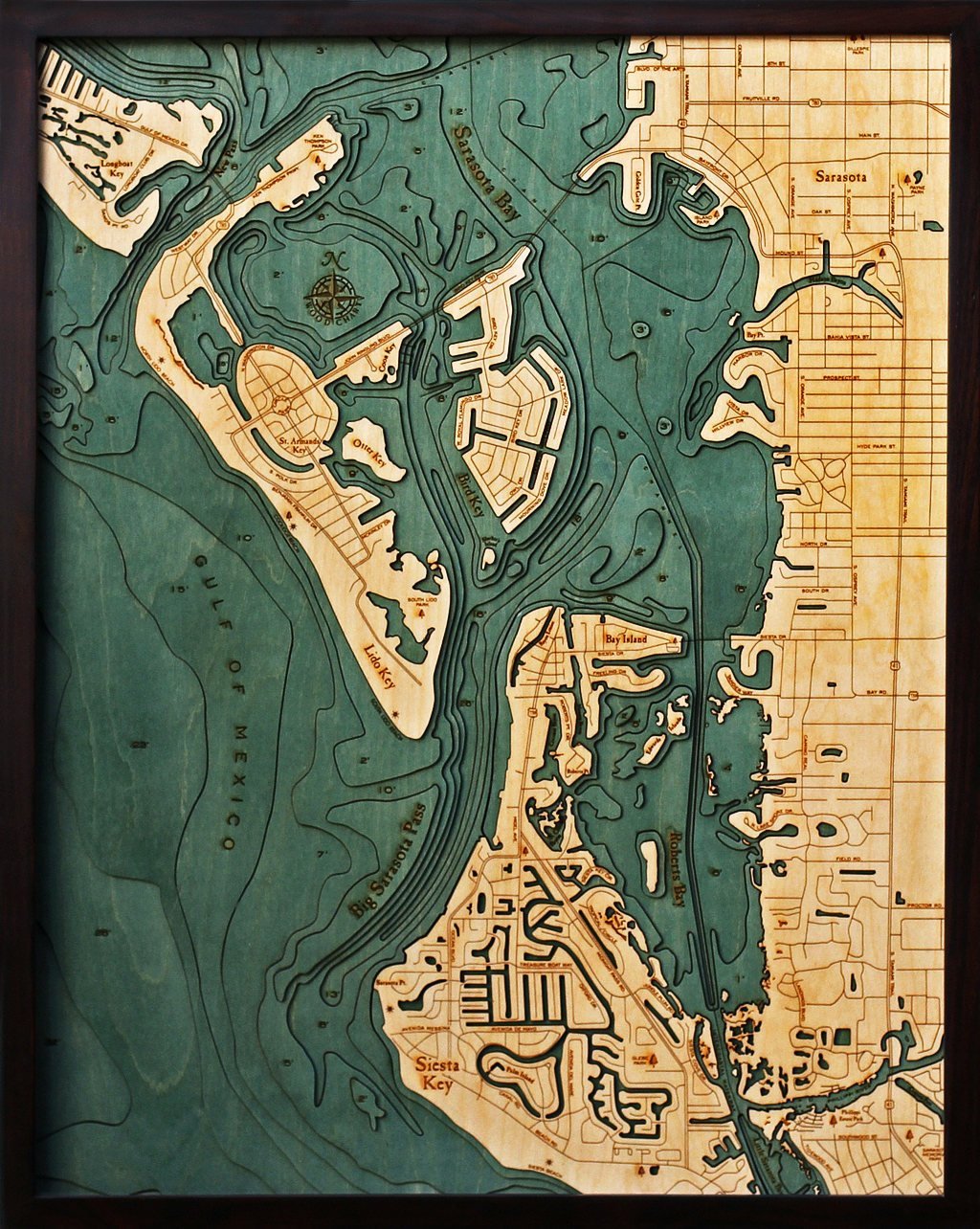 Siesta Key, Florida 3D layered wood map in laser-cut Baltic birch, shown framed against a light wall