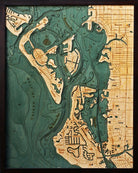 Siesta Key, Florida 3D layered wood map in laser-cut Baltic birch, shown framed against a light wall
