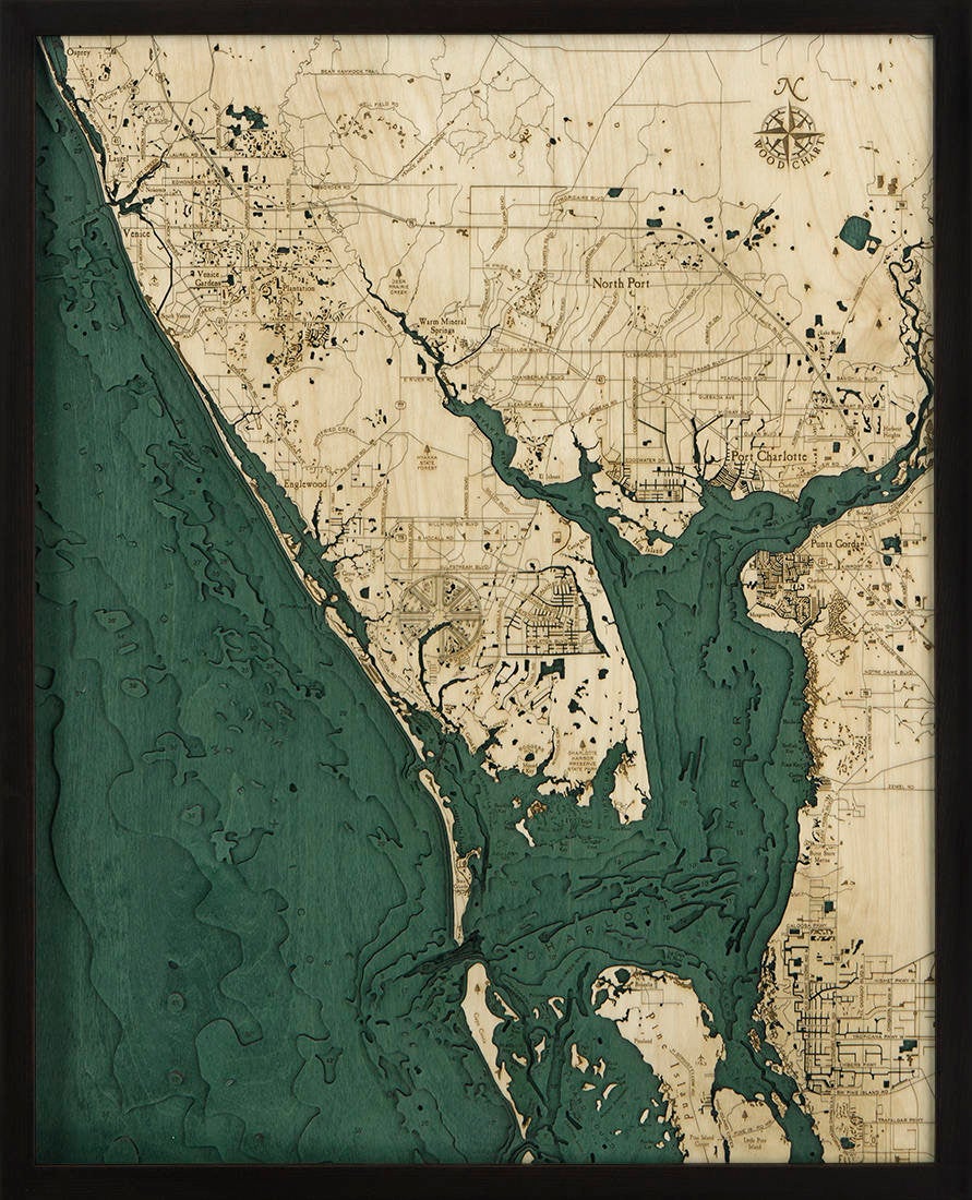 Charlotte Harbor, Florida 3D layered wood map in laser-cut Baltic birch, shown framed against a light wall