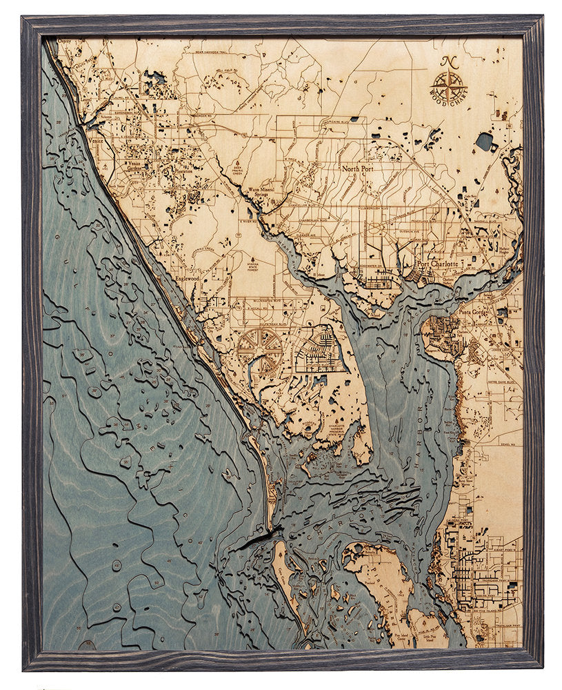 Charlotte Harbor, Florida 3D layered wood map in laser-cut Baltic birch, shown framed against a light wall