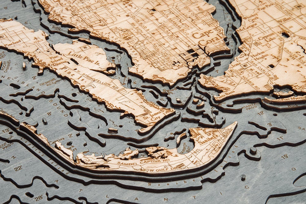 Fort Myers, Florida 3D layered wood map in laser-cut Baltic birch, shown framed against a light wall