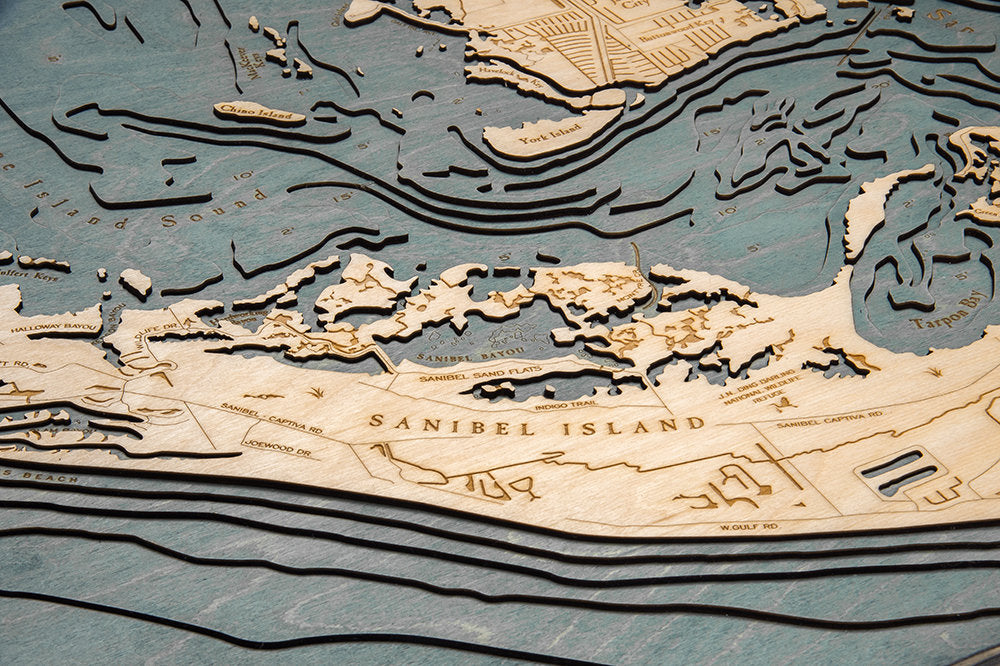 Sanibel Island, Florida 3D layered wood map in laser-cut Baltic birch, shown framed against a light wall