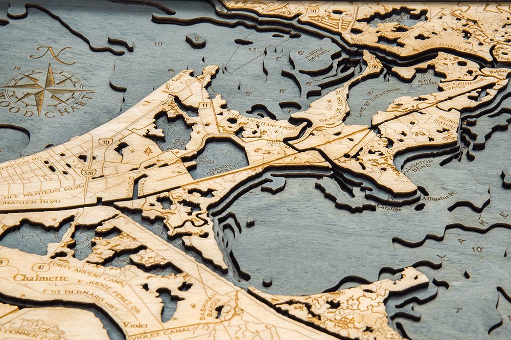 New Orleans, Louisiana 3D layered wood map in laser-cut Baltic birch, shown framed against a light wall