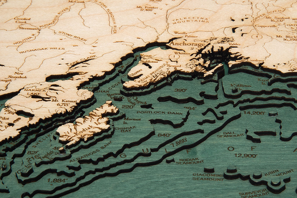 Alaska 3D layered wood map in laser-cut Baltic birch, shown framed against a light wall