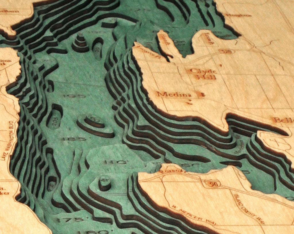 Lake Washington 3D layered wood map in laser-cut Baltic birch, shown framed against a light wall
