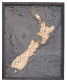 New Zealand 3D layered wood map in laser-cut Baltic birch, shown framed against a light wall
