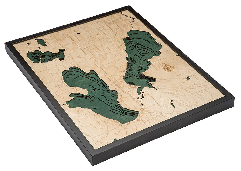 Burt & Mullet Lakes, Michigan 3D layered wood map in laser-cut Baltic birch, shown framed against a light wall