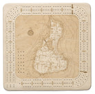 Block Island, Rhode Island wood cribbage board in laser-cut Baltic birch, shown framed against a light wall