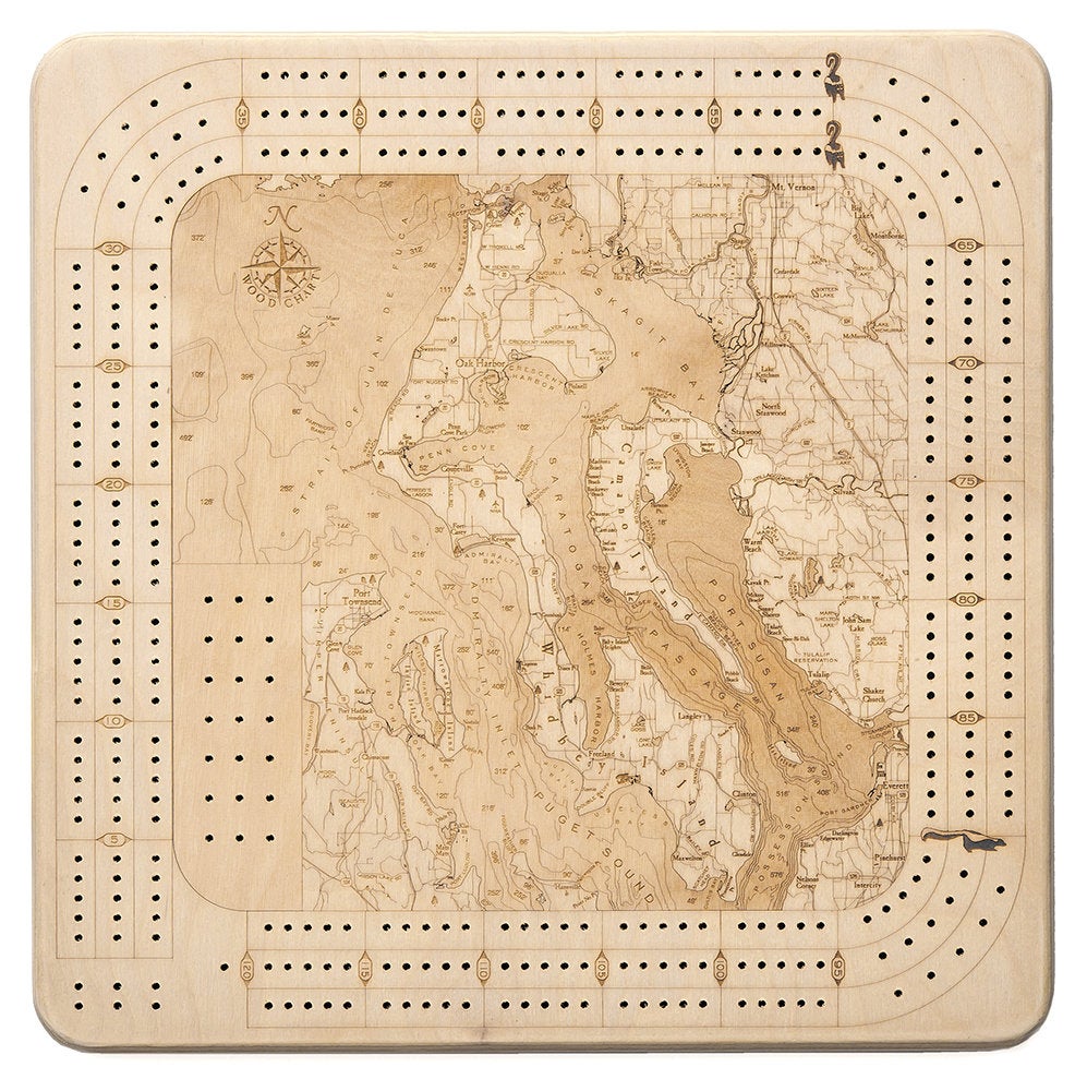 Whidbey & Camano Islands, Washington wood cribbage board in laser-cut Baltic birch, shown framed against a light wall