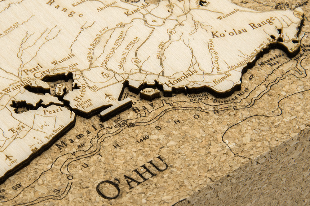 Oahu, Hawaii framed cork map in laser-cut Baltic birch, shown framed against a light wall