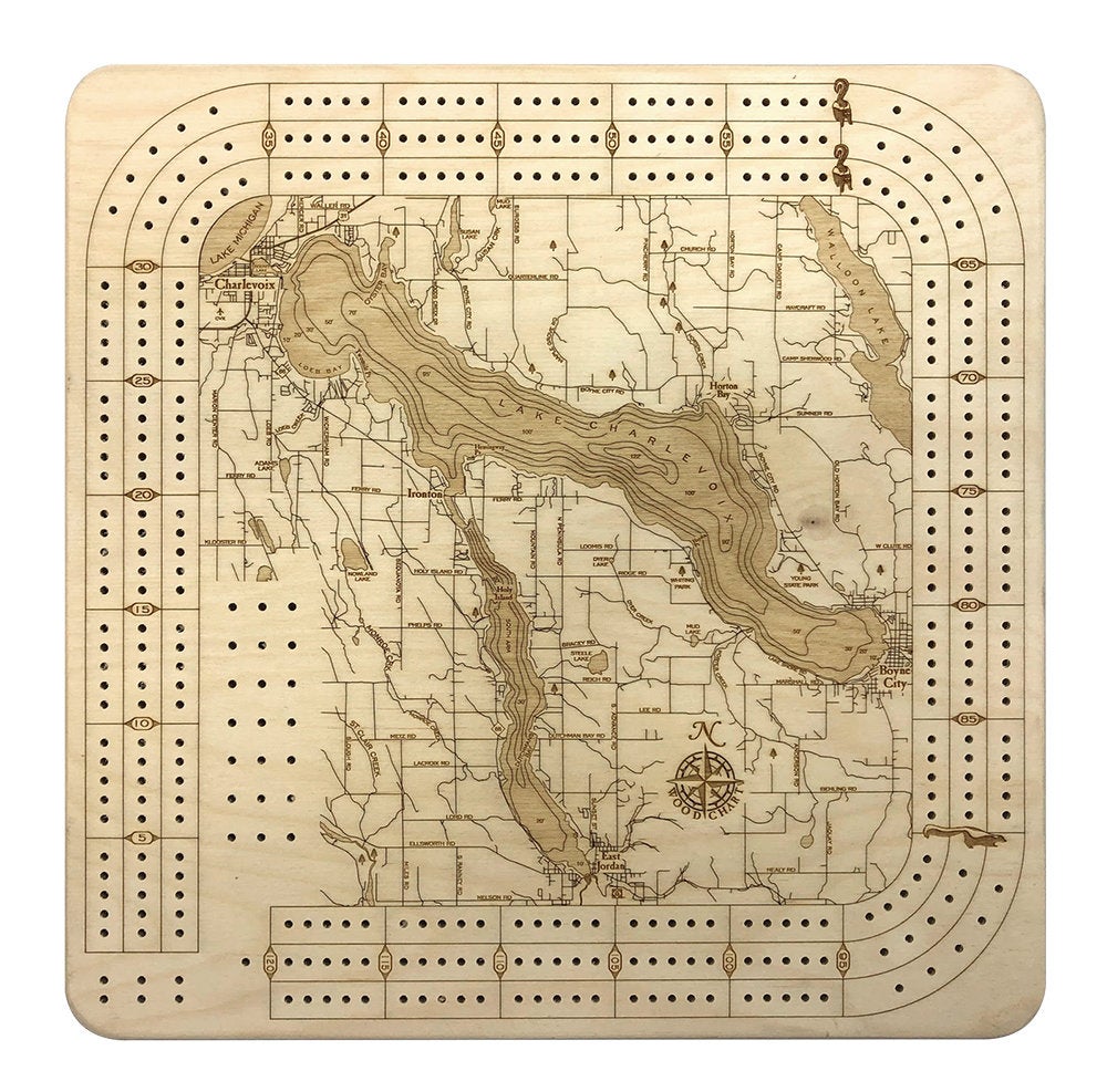 Lake Charlevoix, Michigan wood cribbage board in laser-cut Baltic birch, shown framed against a light wall