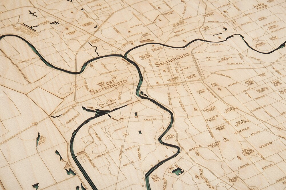 Sacramento, California 3D layered wood map in laser-cut Baltic birch, shown framed against a light wall