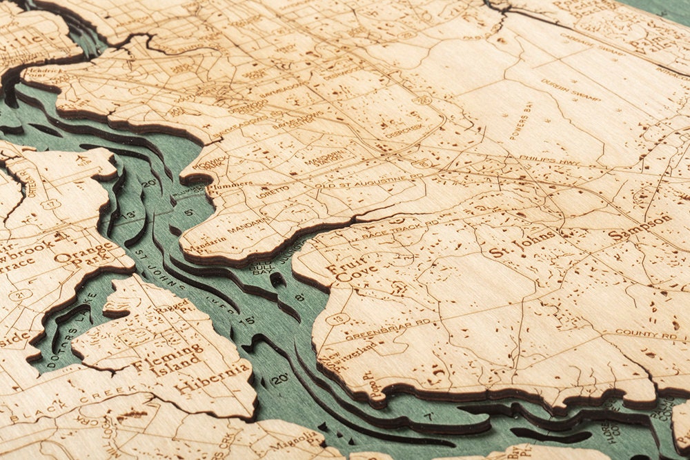 Jacksonville, Florida 3D layered wood map in laser-cut Baltic birch, shown framed against a light wall