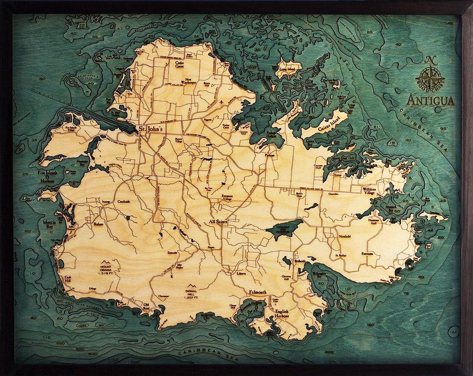 Antigua, Caribbean 3D layered wood map in laser-cut Baltic birch, shown framed against a light wall