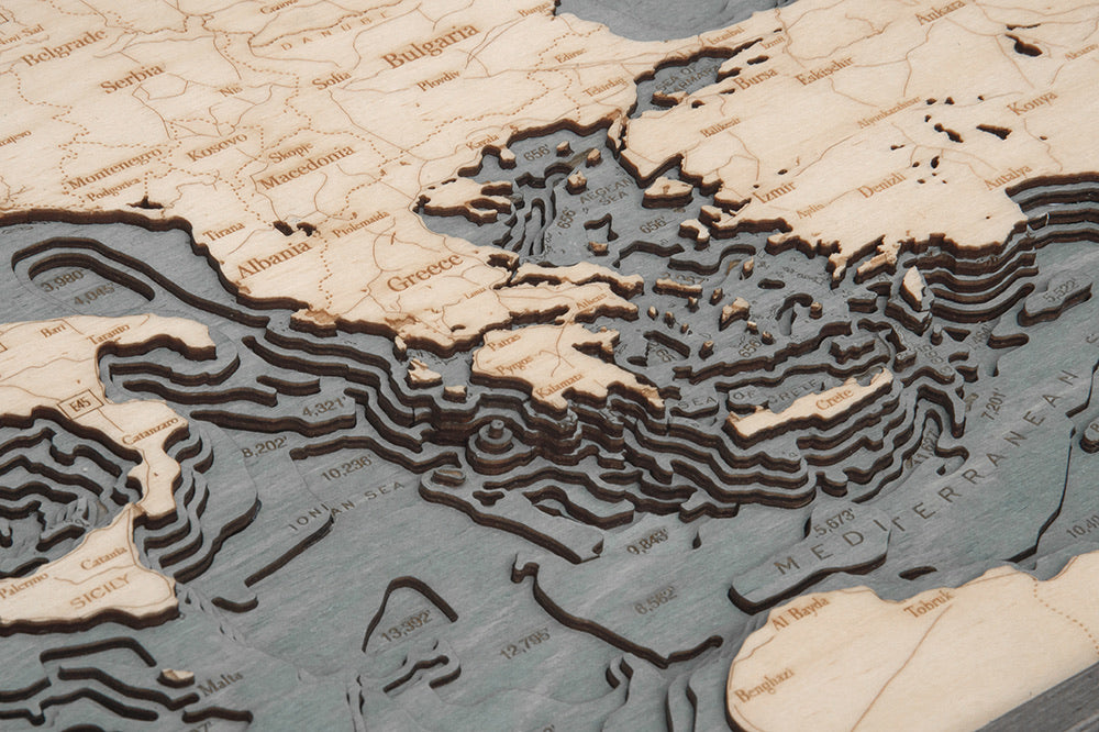 Mediterranean Sea 3D layered wood map in laser-cut Baltic birch, shown framed against a light wall