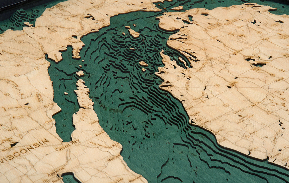 Lake Michigan 3D layered wood map in laser-cut Baltic birch, shown framed against a light wall