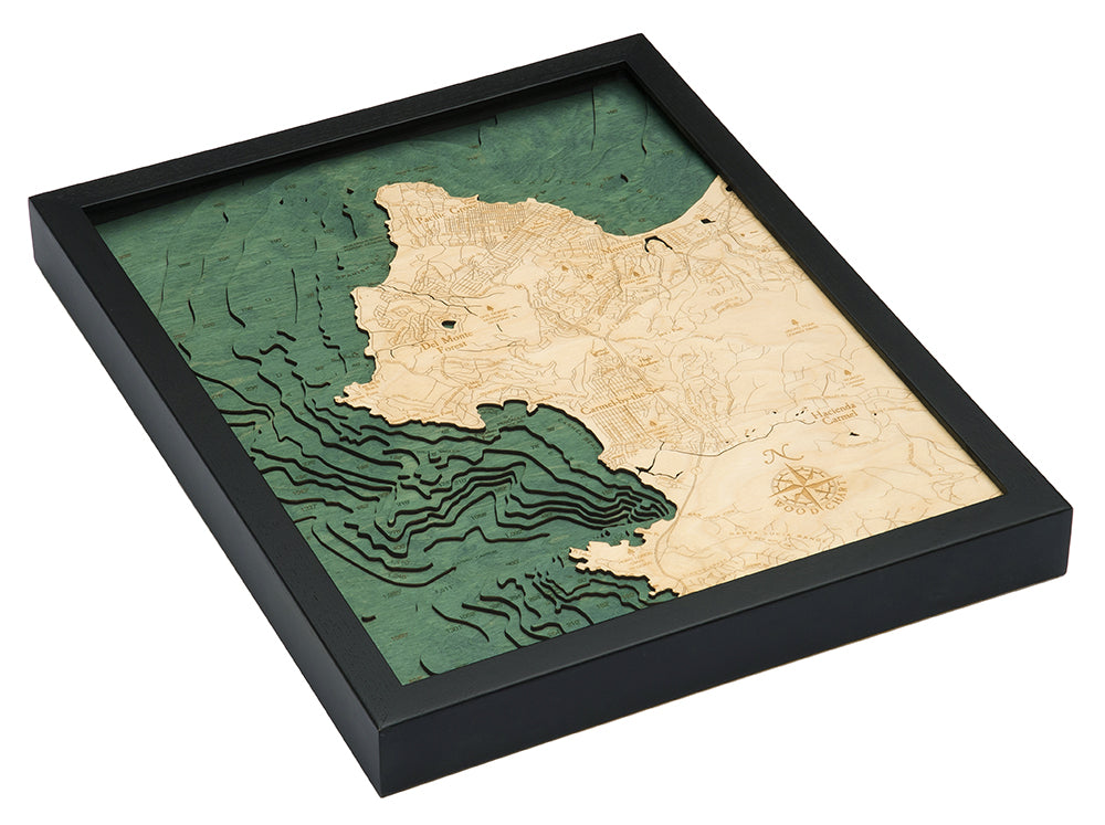 Carmel & Monterey, California 3D layered wood map in laser-cut Baltic birch, shown framed against a light wall