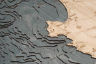 Monterey Bay, California 3D layered wood map in laser-cut Baltic birch, shown framed against a light wall