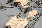 Put-in-Bay, Ohio 3D layered wood map in laser-cut Baltic birch, shown framed against a light wall