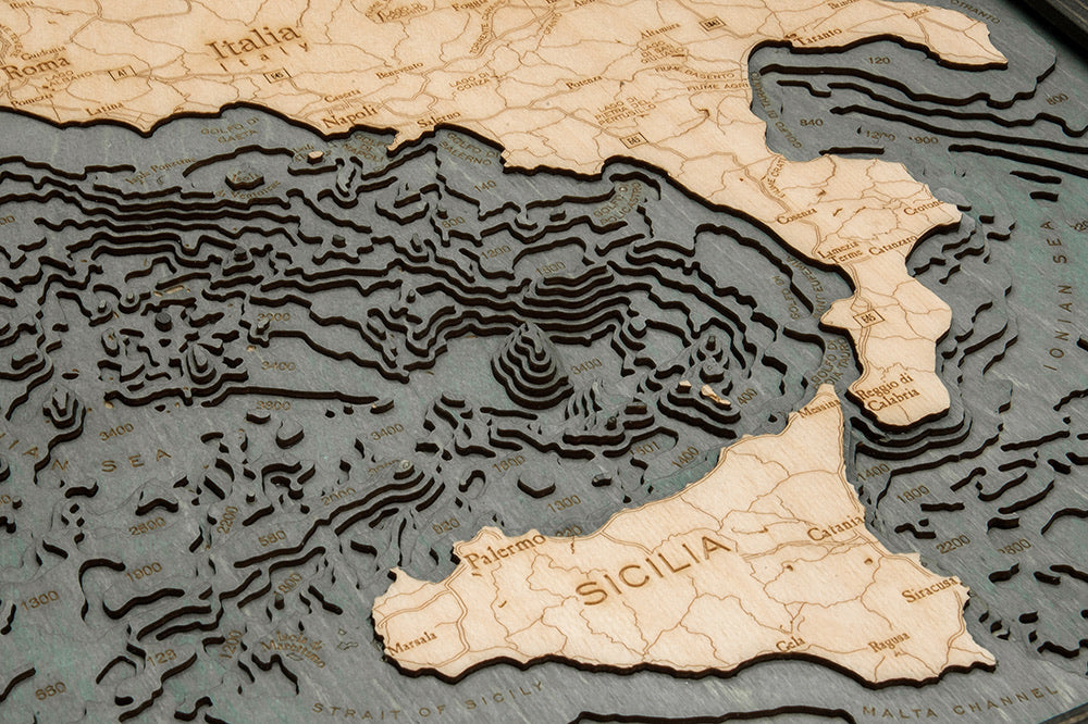 Italy 3D layered wood map in laser-cut Baltic birch, shown framed against a light wall