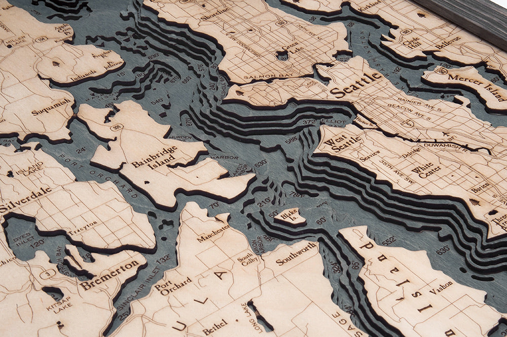 Puget Sound, Washington 3D layered wood map in laser-cut Baltic birch, shown framed against a light wall