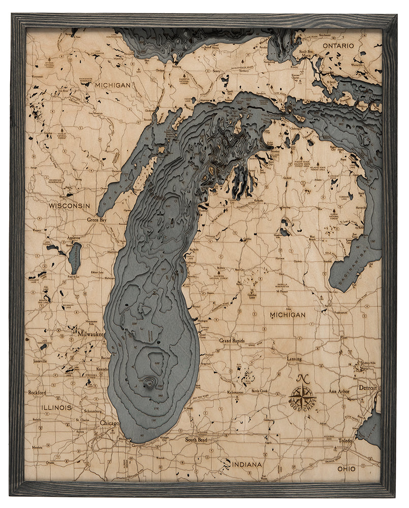 Lake Michigan 3D layered wood map in laser-cut Baltic birch, shown framed against a light wall