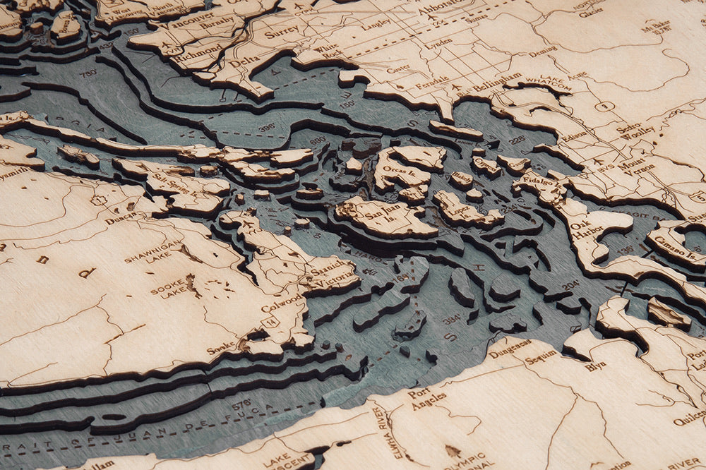 Salish Sea, Washington 3D layered wood map in laser-cut Baltic birch, shown framed against a light wall