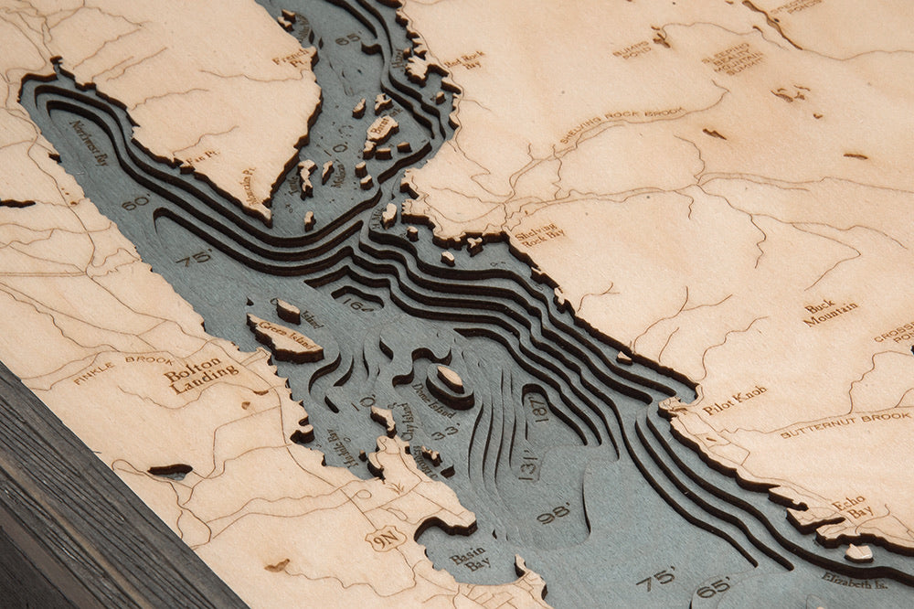 Lake George, New York 3D layered wood map in laser-cut Baltic birch, shown framed against a light wall