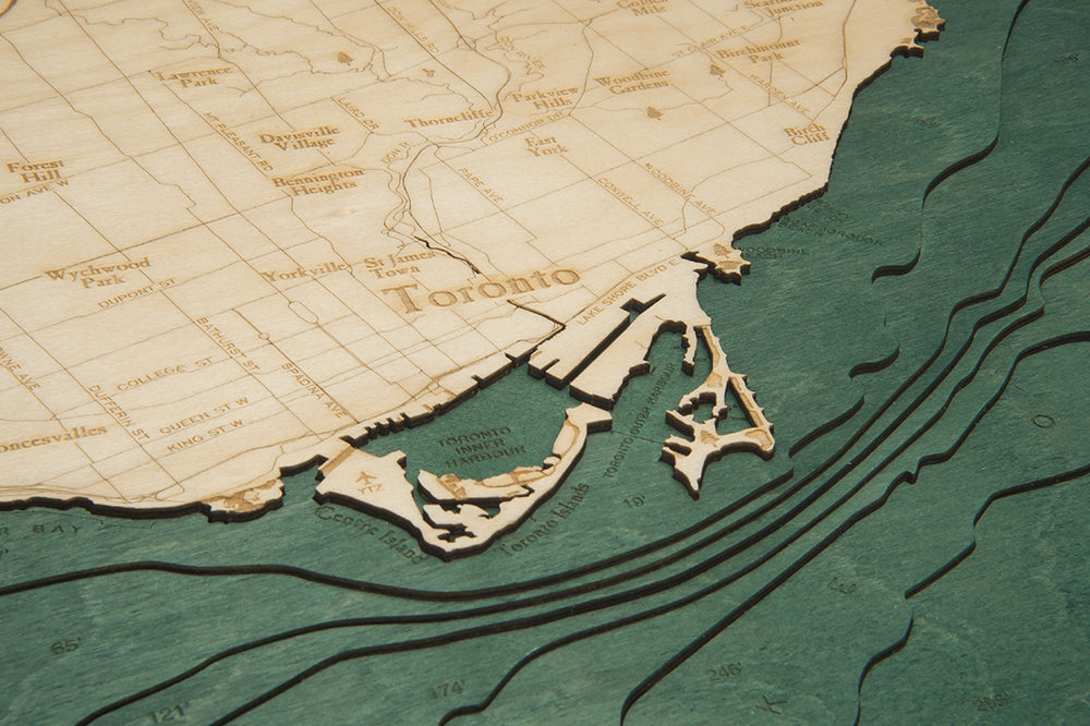 Toronto, Ontario 3D layered wood map in laser-cut Baltic birch, shown framed against a light wall