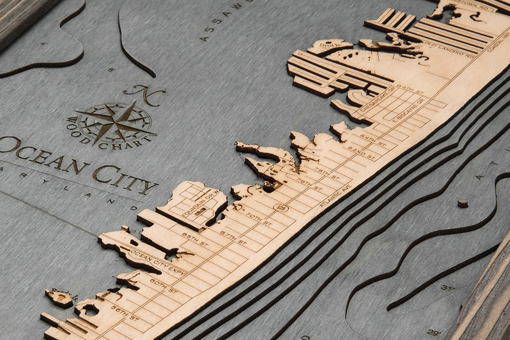 Ocean City, Maryland 3D layered wood map in laser-cut Baltic birch, shown framed against a light wall