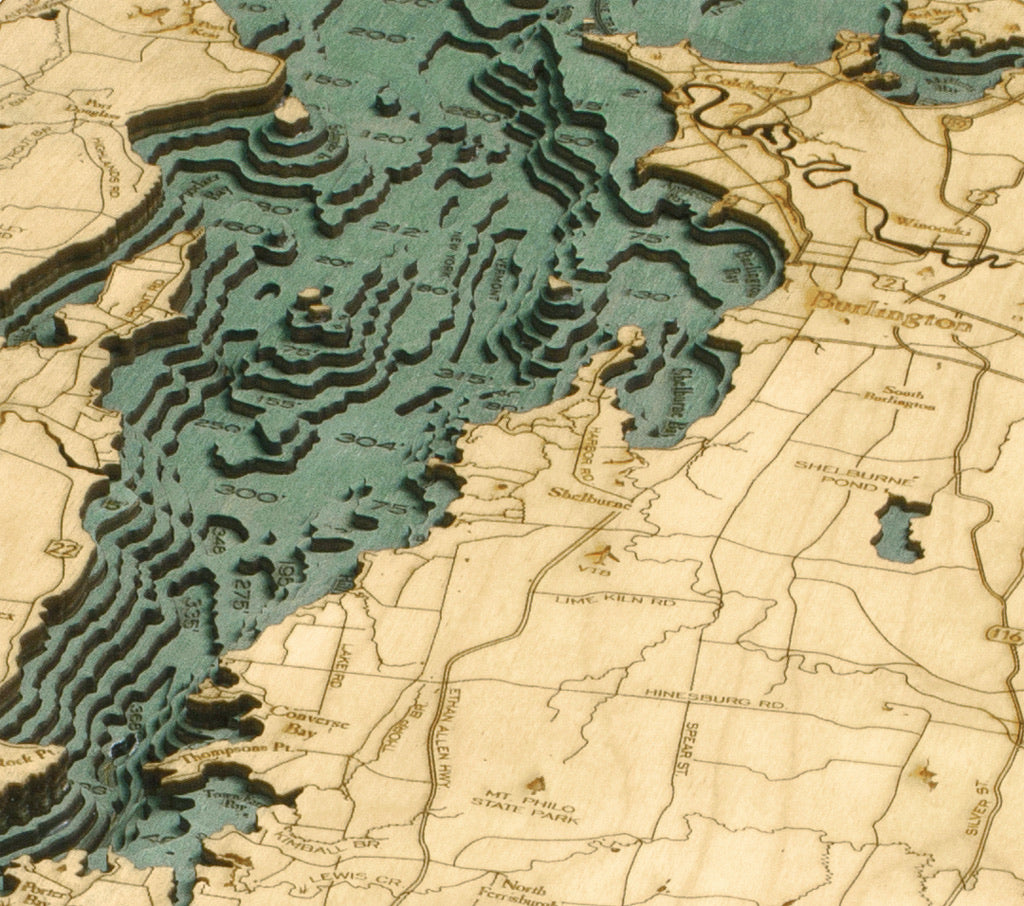 Lake Champlain 3D layered wood map in laser-cut Baltic birch, shown framed against a light wall