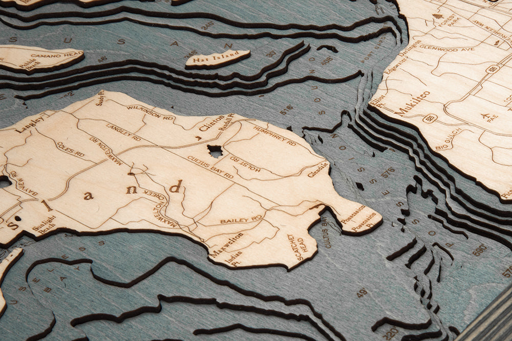 Whidbey & Camano Islands, Washington 3D layered wood map in laser-cut Baltic birch, shown framed against a light wall