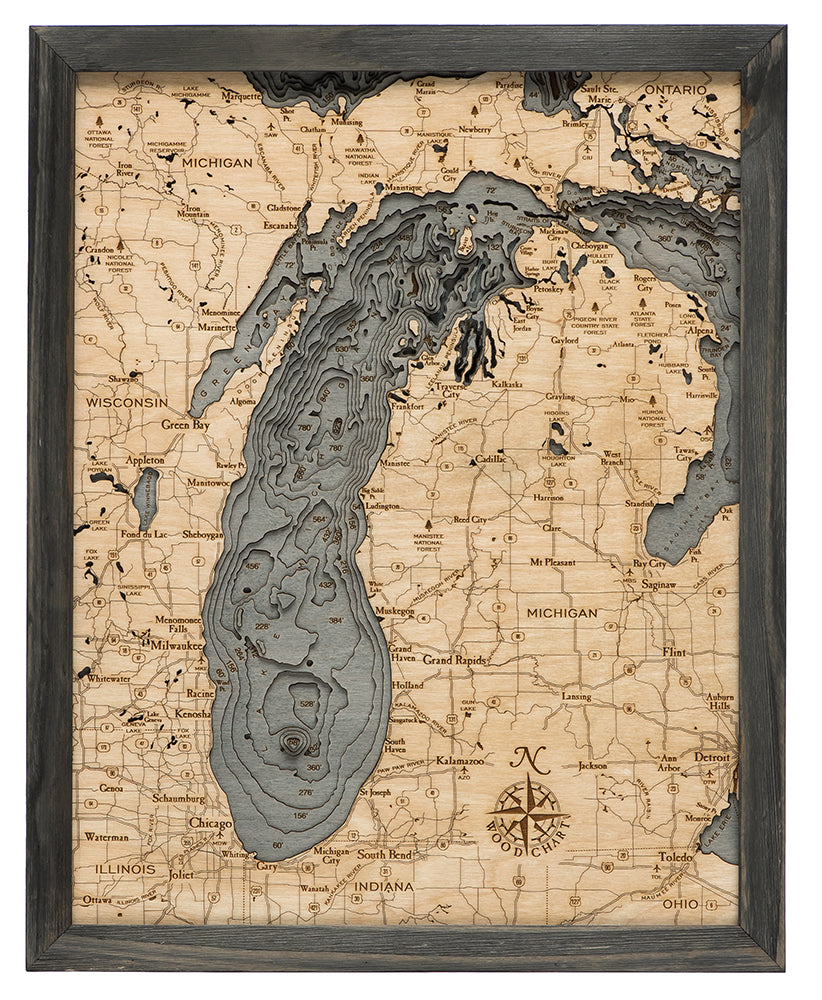 Lake Michigan 3D layered wood map in laser-cut Baltic birch, shown framed against a light wall